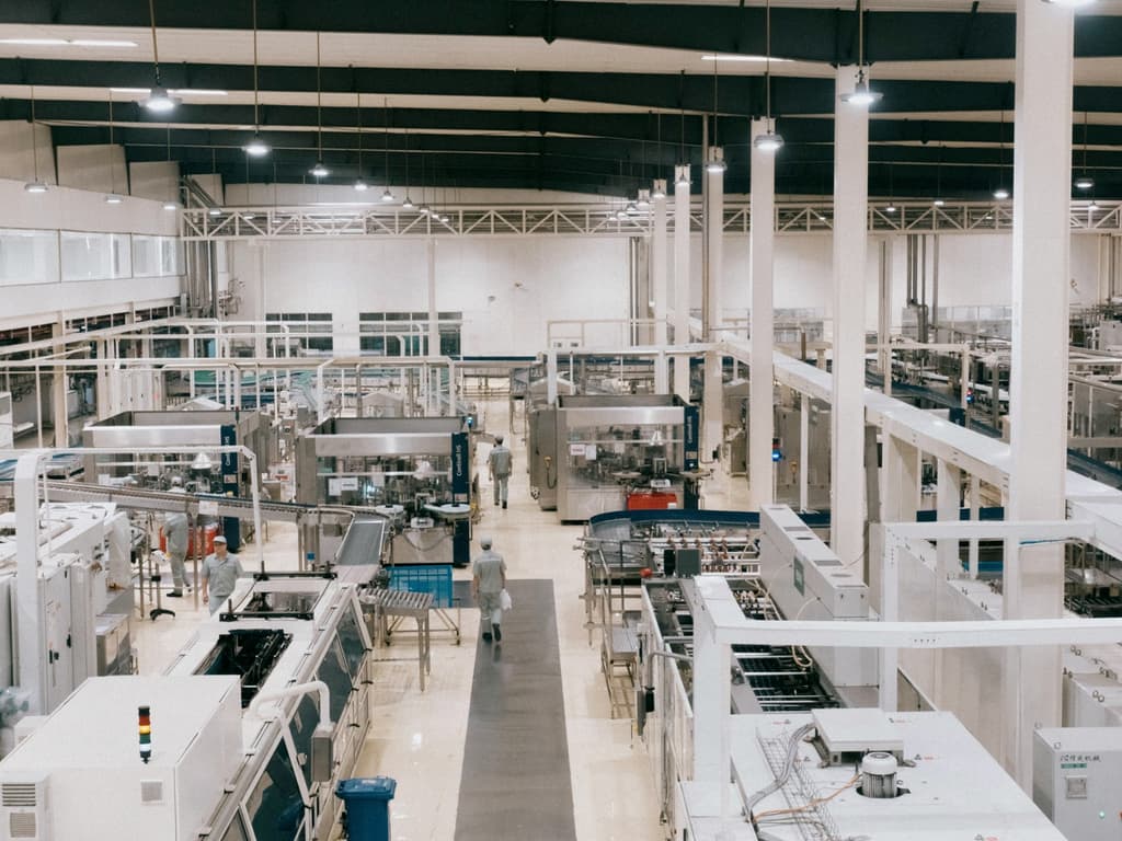 Workers on a modern manufacturing floor between production lines.